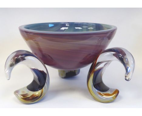 A Murano glass bowl of basin design, elevated on three outset, C-scrolled feet, decorated in colours with random, streaky des