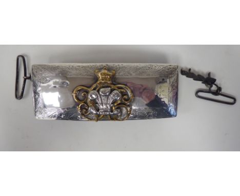 A Victorian British military silver mounted and black hide pouch with foliate engraved border ornament and a yellow and silve