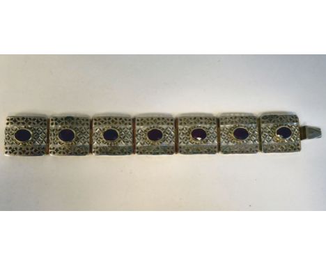 A bi-coloured metal tablet link bracelet, set with a ruby coloured stone&nbsp; boxed with carton