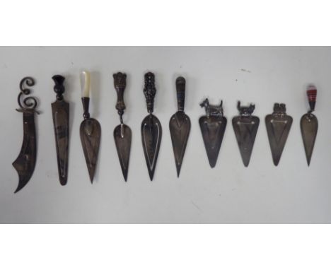Ten variously fashioned late 19th/early 20thC silver, Sterling and white metal novelty page markers, on decoratively mounted 