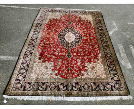 A Persian pure silk rug, decorated with birds, flora and foliate, on a red ground with a black border&nbsp; 78" x 116"