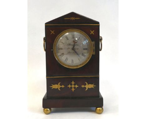 A late Regency mahogany and inlaid brass cased mantel timepiece with a pointed arch top, straight sides, flank ring handles a