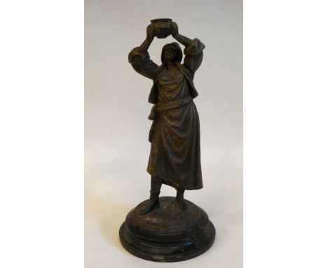 A late 19thC spelter lamp base, a standing figure of a woman with plaits, holding aloft a bowl, on a black ceramic plinth&nbs