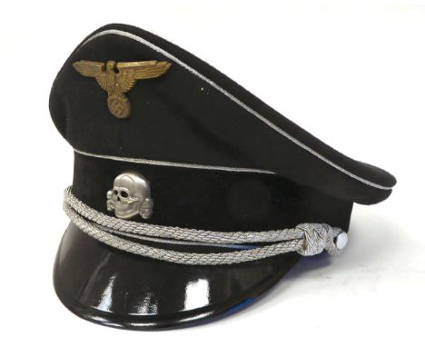 A German SS black peaked cap with silvered piping, emblems and a cord (Please Note: this lot is subject to the statement made