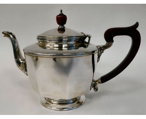 A silver teapot of panelled, octagonal form with a S-shape spout, insulated handle and knop to the outset, hinged lid, on a p