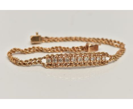 A YELLOW METAL DIAMOND BRACELET, centring on a row of ten round brilliant cut diamonds, estimated total diamond weight 0.50ct