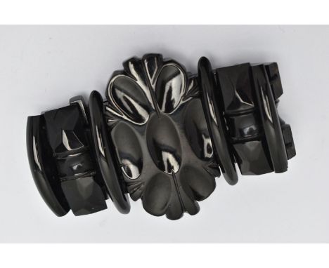 A CARVED JET STRETCH LINK BRACELET, large carved oval centre and carved links, all fitted onto a black cord, approximate gros