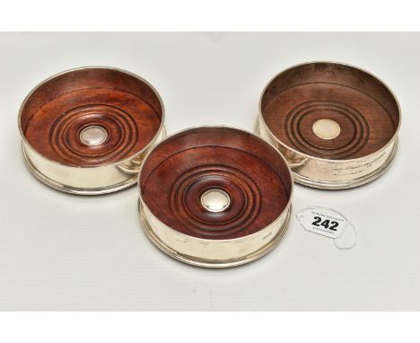 THREE ELIZABETH II SILVER BOTTLE COASTERS, with turned wooden inset bases, green baize to bases, comprising a pair, makers Ha