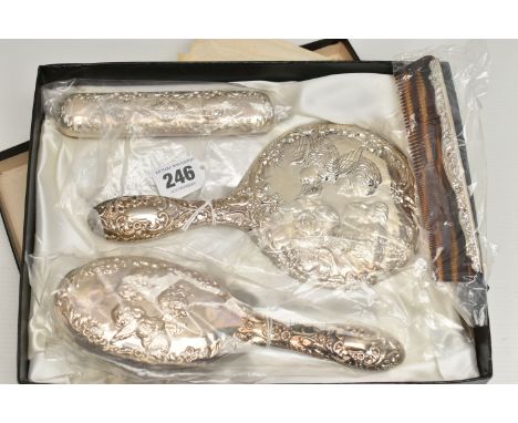 A BOXED ELIZABETH II SILVER MOUNTED FOUR PIECE DRESSING TABLE SET, repoussé decorated with Reynolds Angels, comprising hand m