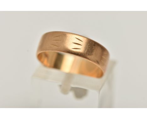A YELLOW METAL WIDE BAND RING, approximate band width 5.5mm, worn textured engraved pattern, stamped 750, ring size leading e