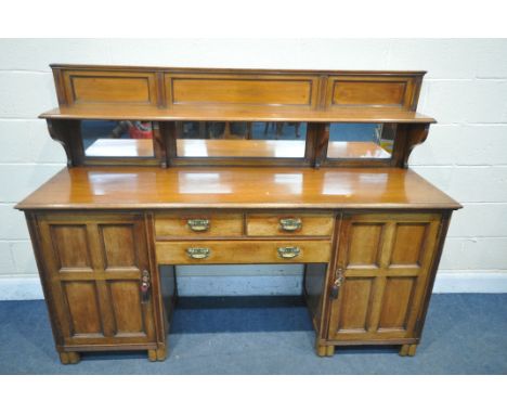 AN EARLY 20TH CENTURY WALNUT PEDESTAL SIDEBOARD, with a raised mirror back and shelf, panel cupboard doors flanking three dra