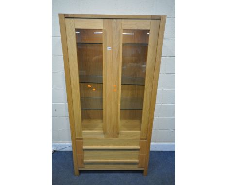 A MARKS AND SPENCER LIGHT OAK GLAZED TWO DOOR ILLUMINATED DISPLAY CABINET, with two drawers, width 95cm x depth 44cm x height