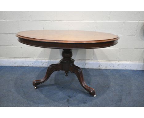 A VICTORIAN MAHOGANY CIRCULAR TIL TOP TRIPOD TABLE, on a turned plinth, scrolled legs, with two brass castors and one ceramic