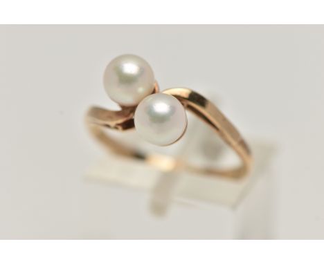 A CULTURED PEARL RING, two cultured pearls set in a yellow metal bypass mount, unmarked, ring size N 1/2, approximate gross w
