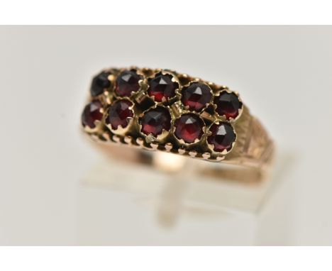 A LATE VICTORIAN 9CT GOLD GARNET RING, designed with two rows of five rose cut garnets, to a textured scrolling band, hallmar