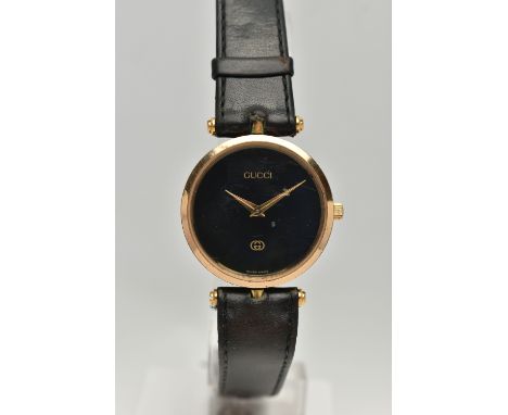 A VINTAGE LADYS GOLD PLATED QUARTZ GUCCI WRISTWATCH, round black dial signed Gucci, case width approximately 30mm, case sides
