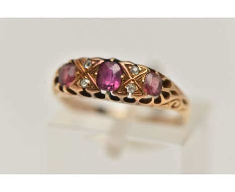 A YELLOW METAL GEM SET RING, a centrally set oval cut ruby, four old cut diamonds, two oval cut pink paste stones, prong set 