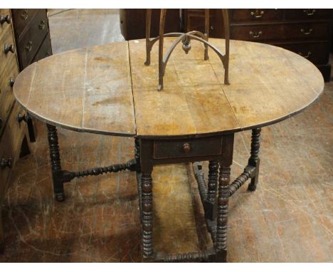 1x drop leaf oak oval table. Historic repairs to the natural split in the wood. turned legs and stretchers. Solid but in used