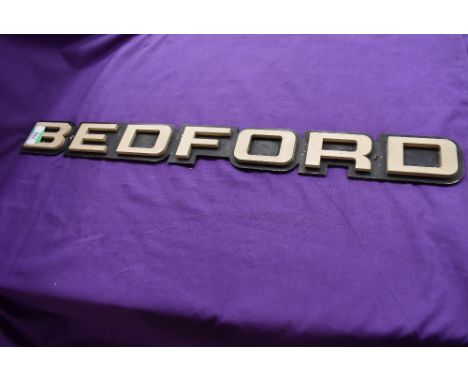 A vintage Bedford truck engine badge with raised lettering