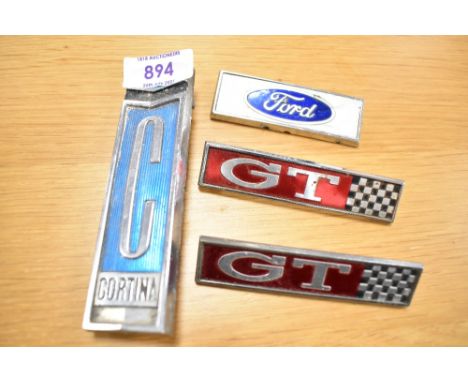 Four vintage motor car engine badges, a Ford Cortina, two GT and a Ford
