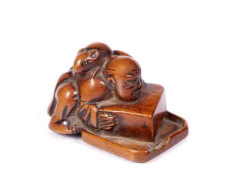 Wood netsuke of a semi kneeling disappointed rat catcher Japanese, 18th Century depicted leaning forward over his box trap wh