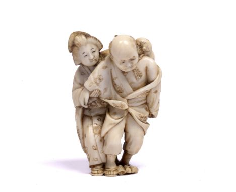 Ivory netsuke carved as a standing Geisha Japanese, late Meiji standing behind and assisting an elderly gentlemen, a double g