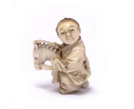 Ivory miniature netsuke of a boy Japanese, late Meiji child riding a hobby horse, robes engraved with floral motifs