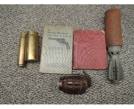 A dummy Grenade and Mortar Bomb along with two small brass Shell Cases one marked 1942, Infantry Training Manual 1914 and a S