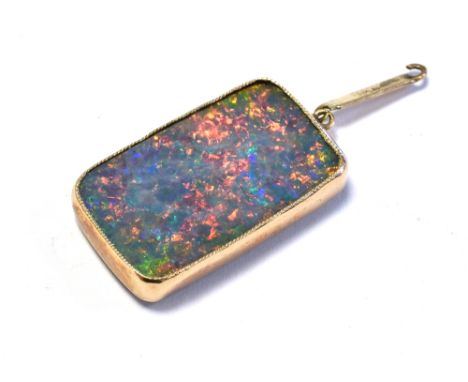 OPAL PENDANT SET IN 9CT GOLD 22.0 x 13.1mm rectangular opal doublet, showing a good play of colour in a broad flash pattern. 
