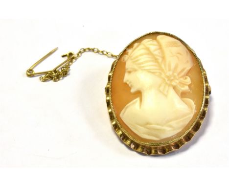 SHELL CAMEO BROOCH SET IN 9CT GOLD depicting a classical female with bonnet, bezel set in a scalloped edge gold frame, hallma