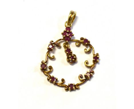 9CT GOLD &amp; RUBY SET PENDANT 3.5cm long x 2.3cm wide, of floral scroll work design, set with round cut rubies, Hallmarked 