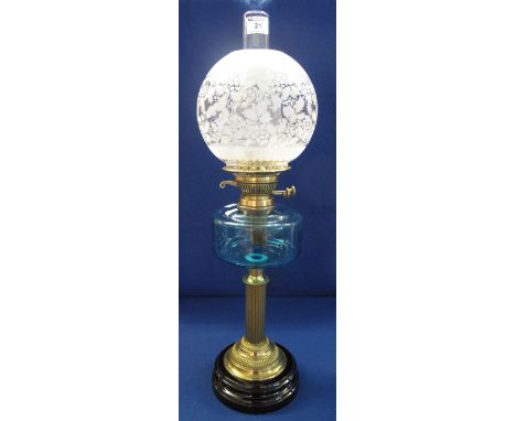 Early 20th Century brass double burner oil lamp with coloured glass reservoir, on brass pedestal with ceramic base, etched gl