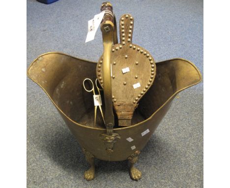 Brass helmet shaped coal scuttle on four paw feet, together with leather bellows and brass coal tongs. (B.P. 24% incl. VAT)