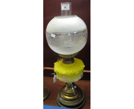 Early 20th Century brass double burner oil lamp with relief decorated, coloured glass reservoir on brass pedestal with cerami