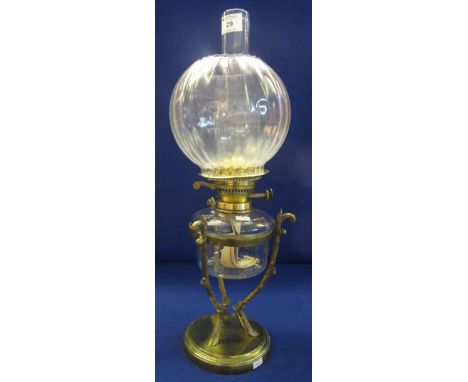 Early 20th Century brass double burner oil lamp with clear glass reservoir on a brass, three legged frame stand with circular