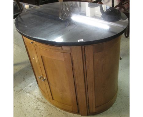 Elegant modern French oak oval kitchen island with black granite work surface, with six doors, fitted cupboards, fixed shelf 