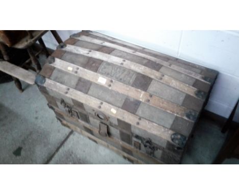 A canvas and wooden bound dome topped trunk initialled E.W.H.