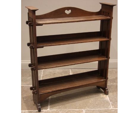An Arts & Crafts oak open bookcase, the arched gallery to the upper shelf pierced with a heart shaped motif, over three furth
