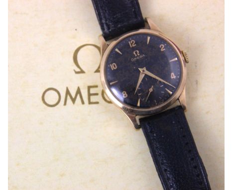 A yellow metal cased Omega wristwatch, the circular marbled black dial with arrow head and Arabic numerals, subsidiary dial t