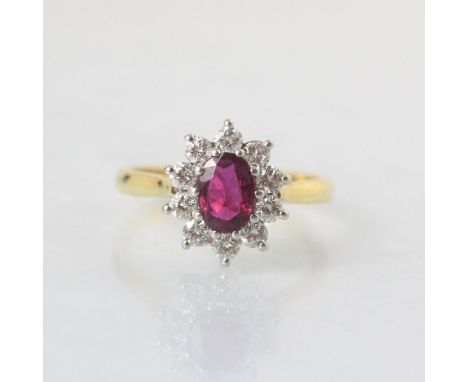 An Edwardian style untested ruby and diamond ring, the central oval cut untested ruby surrounded by ten round cut diamonds, w