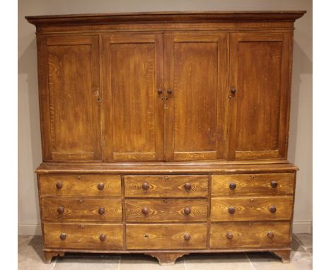 A Victorian scumbled pine housekeepers cupboard, the moulded cornice over a central pair of cupboard doors opening to two she