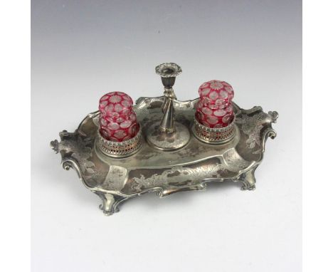 A 19th century silver plated desk tidy, the scroll handle above florally engraved detail and crest to centre, with two cranbe