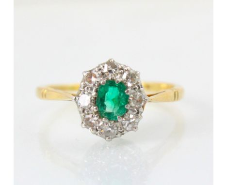 An Edwardian style untested emerald and diamond cluster, the emerald cut green stone within surround of eight round cut diamo