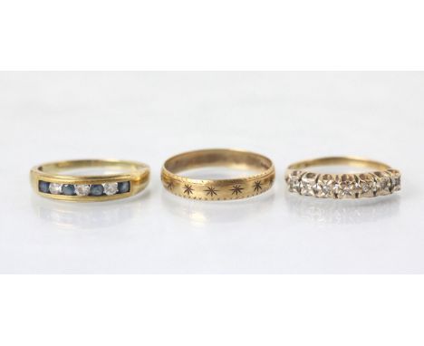 A selection of three rings, including a 9ct yellow gold band ring, with engraved star decoration, stamped 'MS&amp;S' London  
