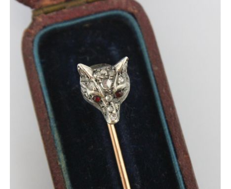 A 19th century diamond set foxes head stick pin, the fox head set with fifteen mixed cut diamonds and red stone cabochon set 