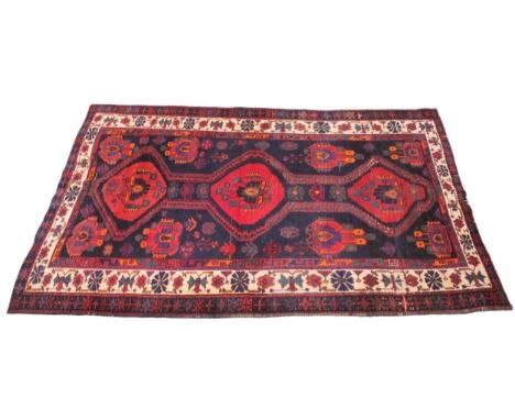 A vintage Persian Nahavan rug, bespoke design, rich colourways of blue, red orange and green, the three linked central red me