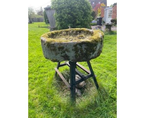 A circular sandstone trough, with associated painted iron stand, 25cm H x 83cm D 