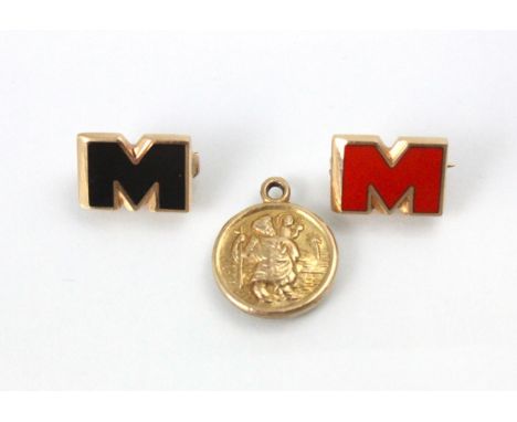 Two yellow metal and enamel brooches, designed as 'M' in black and red enamel, with hinge pin to reverse stamped '10k' with a