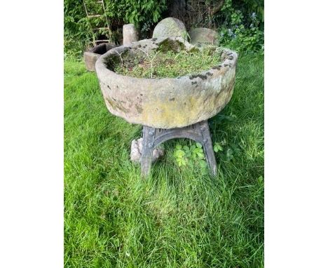A circular sandstone trough, with associated painted iron stand, 26cm H x 82cm D 