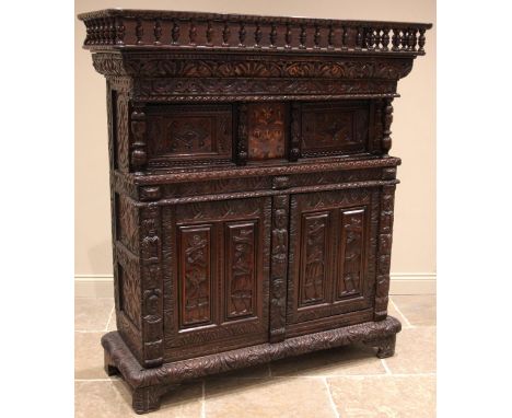 A 17th century and later oak profusely carved court cupboard, the later spindle gallery over a central foliate marquetry pane